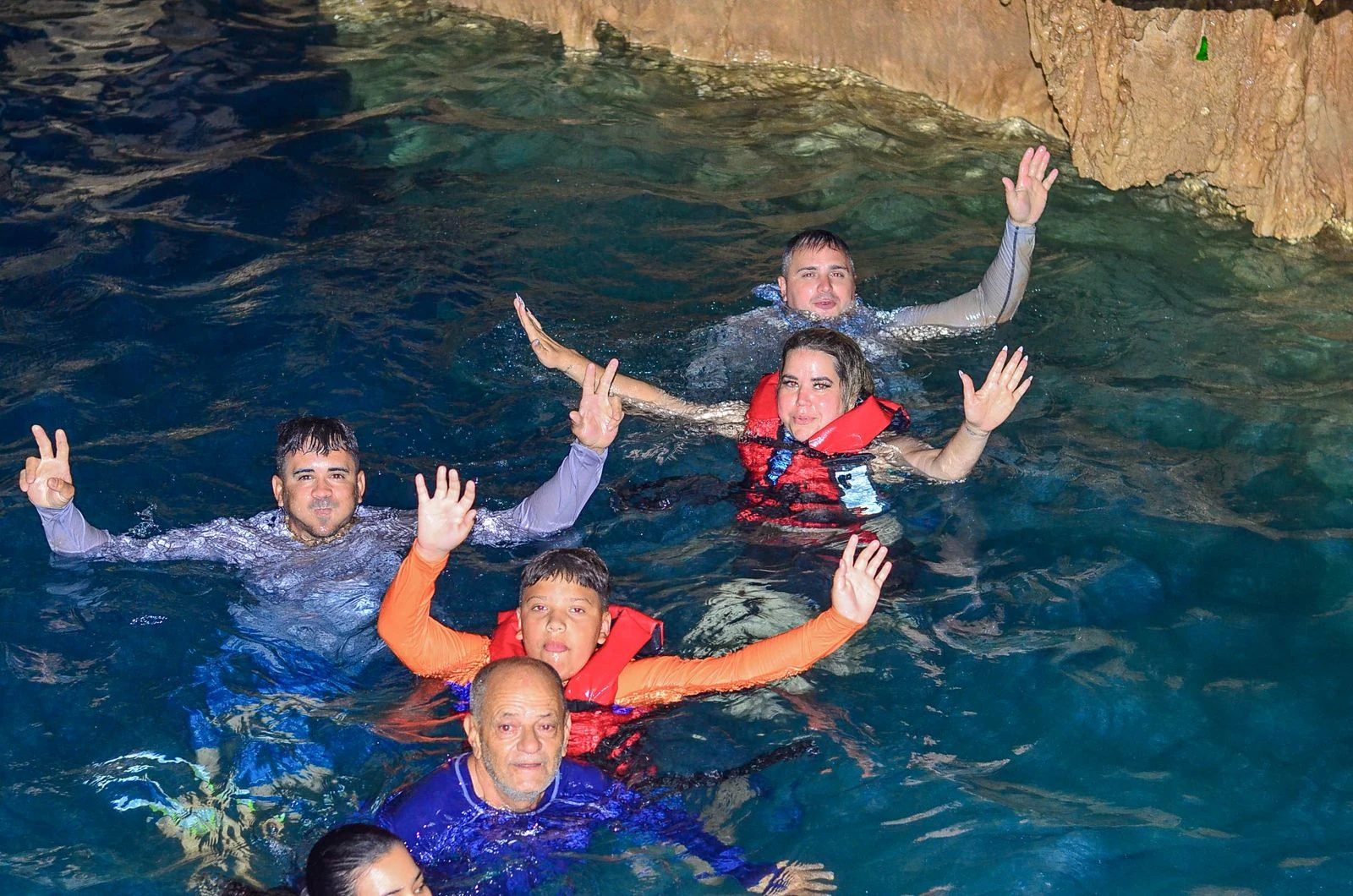 Grupo de visitantes en el agua de un cenote durante una salida de buggies