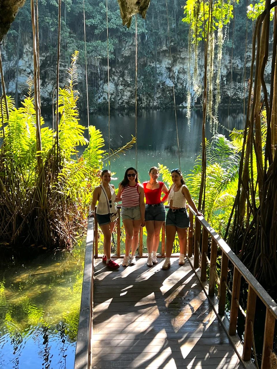 Visitantes junto a una laguna y vegetación en Los Tres Ojos
